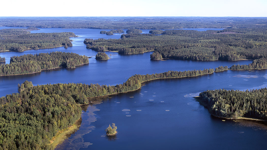Flygfoto som visar sjön och trädbevuxna öar på sommaren.