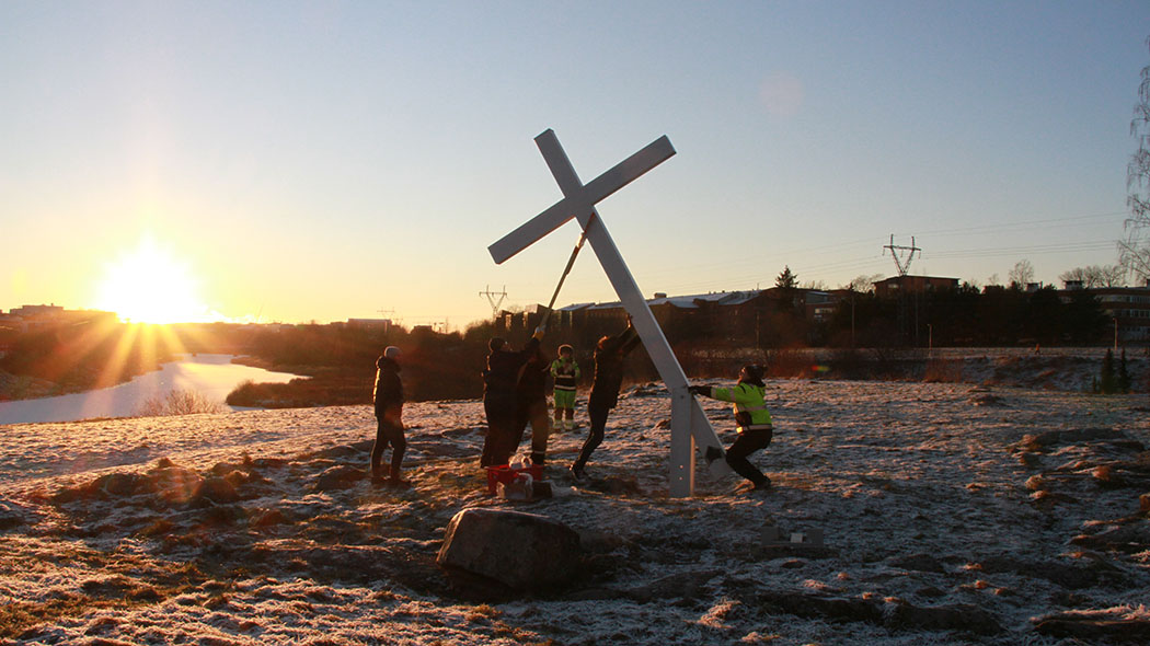 Flera personer höjer korset.